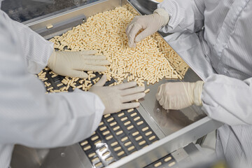 Macro Shot of colour Pills and Capsules During Production and Packing Process on Modern Pharmaceutical Factory. Tablet and Capsule Manufacturing Process. Close-up Shot of Medical Drug Production Line.