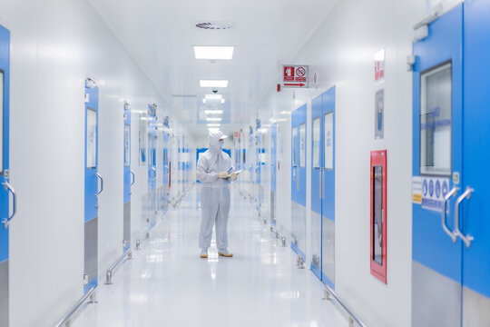 Focus chemistry man with biochemistry suit at the Walkway in the spacious and bright laboratory workplace for doctor and scientist in Pharma business factory.