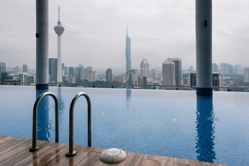 Swimming pool on the roof of skyscraper and panorama of the city with Kuala Lumpur and Merdeka 118...