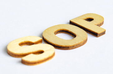 SOP wooden text on white notepad. Standard operating procedure concept.