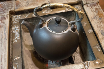 Traditional metal Chinese kettle on coals boiling water for tea. High quality 4k footage.
