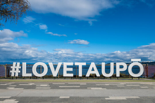 Hashtag Love Taupo sign in front of Lake Taupo in New Zealand.