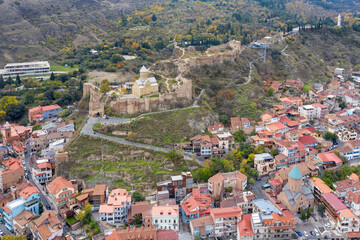 Aerial view of Old Town, Narikala Fortress, Saint Nicholas's Church and St. George Cathedral  on cloudy day. Tbilisi, Georgia.