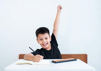 Asian boy in homeschool feeling happy Have the intention to use the abacus in learning math, education concept, Social distancing, stay home, presenting a modern educational lifestyle