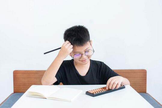 Asian boy in homeschool feeling happy Have the intention to use the abacus in learning math, education concept, Social distancing, stay home, presenting a modern educational lifestyle