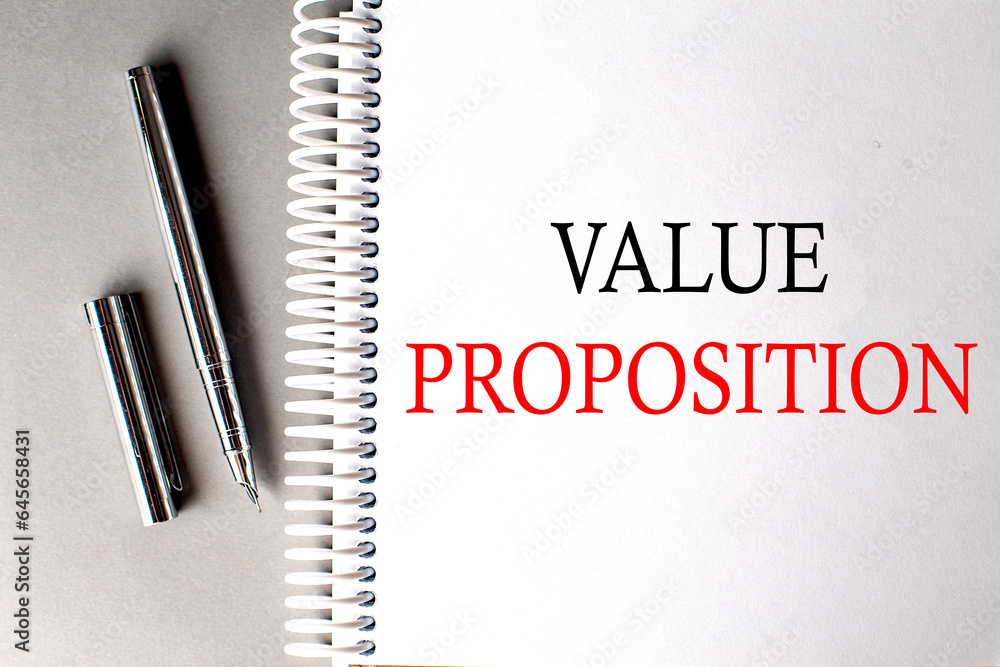 Poster value proposition text on a notebook with pen on grey background