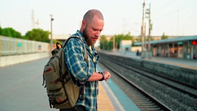 Man with backpack awaiting metro train on railway platform. Public transport. Urban life citizen going to work in morning using subway.