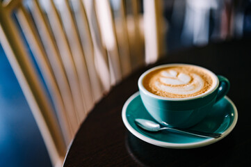 Coffee cappuccino in cup on wooden table in cafe