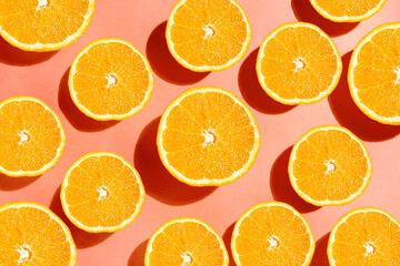 Orange slices top view on peach colored background