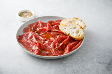 Traditional beef carpaccio with baguette bread