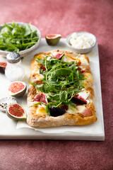 Homemade pizza with figs and arugula