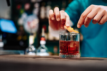 bartender hand making negroni cocktail