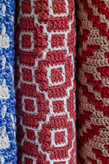 Stacked red and blue crochet pillows.