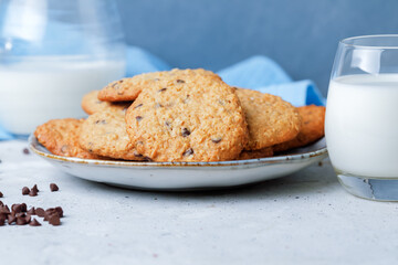 Oats and Chocolate chip cookies with milk on grey table background.