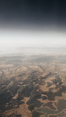 Clouds above the ground. Clouds and ground from the airplane window.