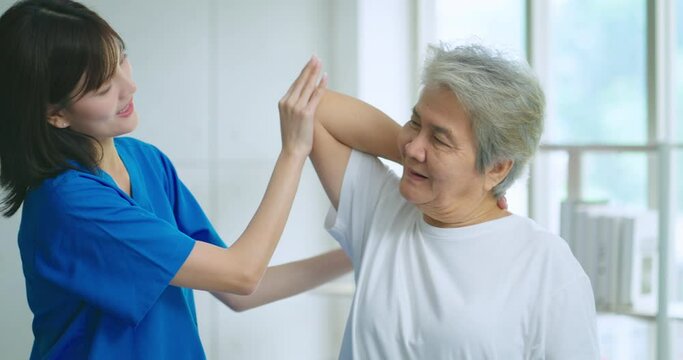 Beautiful asian nurse taking care of senior woman to exercise at hospital. She feeling happy when take care senior woman. Healthcare, Retirement, Volunteer, Caregiver and Lifestyle concept.