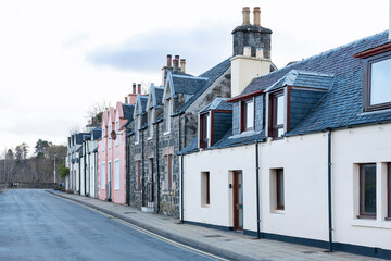 Fototapeta na wymiar Main street of the Scottish town lined with old traditional fishermen's houses, capital of the picturesque island of the Inner Hebrides archipelago, Portree, Isle of Skye, Scotland, UK