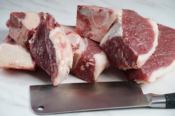 Fresh raw beef steaks with bone on cutting board ready for cooking Asado