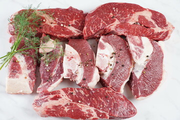Plain fresh beef cut chuck steak and raw steaks with bone on cutting board prepared for cooking