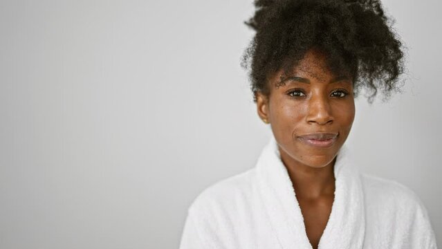 African american woman wearing bathrobe smiling over isolated white background