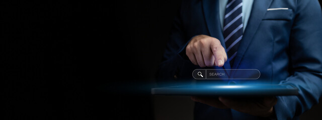 Person with search box hologram, businessman type a search term into the search box on the internet to find the information he is looking for. Information search concept.