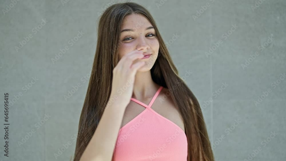 Poster Young beautiful girl smiling confident combing hair over isolated white background