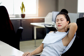 Tired beautiful Asian woman officer relieve physical tension after working hard during take break...