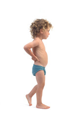 Obraz premium side view of a boy in underpants walking with arms akimbo on white background (3 year old)