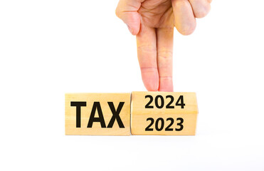 2024 tax new year symbol. Businessman turns a wooden cube and changes words Tax 2023 to Tax 2024. Beautiful white table white background, copy space. Business 2024 tax new year concept.