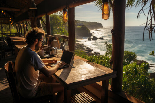 Man Working On Laptop At Cafe By The Beach