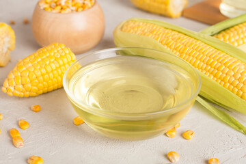 Corn oil with fresh cobs on wooden table