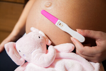 Pregnancy test in pink color. Test positive. Pregnancy test concept. Motherhood concept.