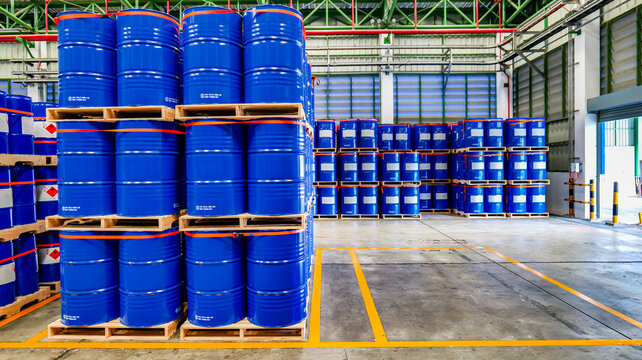 Blue 200 liter chemical and oil drums arranged on pallets. Stored in an orderly warehouse. to wait for delivery