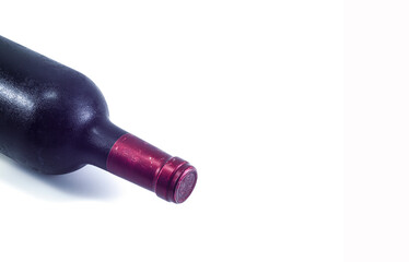 A bottle of wine from a cold cellar on a white background.