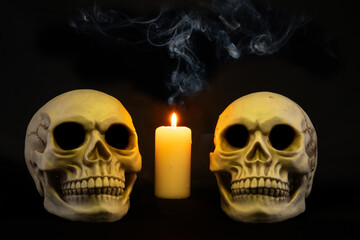 two human skulls in canldle light