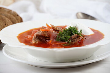Traditional Ukrainian borscht . White plate of red beet root soup borsch with white cream . Beet Root delicious soup . Traditional Ukraine food cuisine