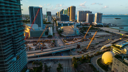 construction site in Miami downtown with traffic car road aerial drone fly above skyscraper building and main highway road with cars 