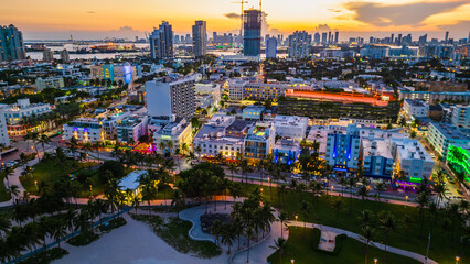 Aerial drone above Miami South beach ocean road illuminated at dusk sunset  - obrazy, fototapety, plakaty
