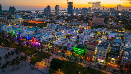 Miami South beach illuminated skyline cityscape at night during sunset drone aerial above ocean road 