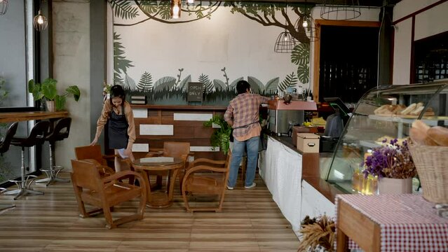 Elderly Asian mothers, with daughter who is owner cafe where two them are helping clean up, keep shop always clean every day, clean up bakery after closing in evening, prepare open tomorrow.