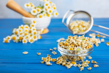 Dry chamomile flowers on a wooden table. Soothing chamomile tea. Herbal drink. flat layout. Space for text.Copy space.Medical prevention and immune concept. Folk alternative medicine.
