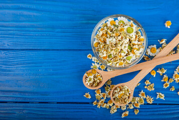Dry chamomile flowers on a wooden table. Soothing chamomile tea. Herbal drink. flat layout. Space for text.Copy space.Medical prevention and immune concept. Folk alternative medicine.