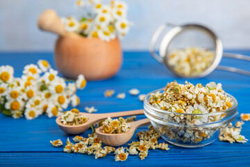 Dry chamomile flowers on a wooden table. Soothing chamomile tea. Herbal drink. flat layout. Space for text.Copy space.Medical prevention and immune concept. Folk alternative medicine.