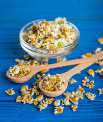 Obraz na płótnie Canvas Dry chamomile flowers on a wooden table. Soothing chamomile tea. Herbal drink. flat layout. Space for text.Copy space.Medical prevention and immune concept. Folk alternative medicine.