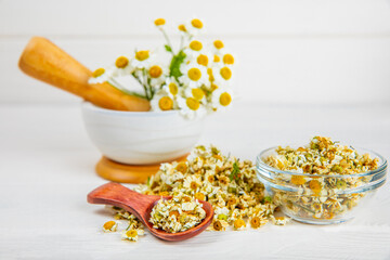 Dry chamomile flowers on a wooden table. Soothing chamomile tea. Herbal drink. flat layout. Space for text.Copy space.Medical prevention and immune concept. Folk alternative medicine.