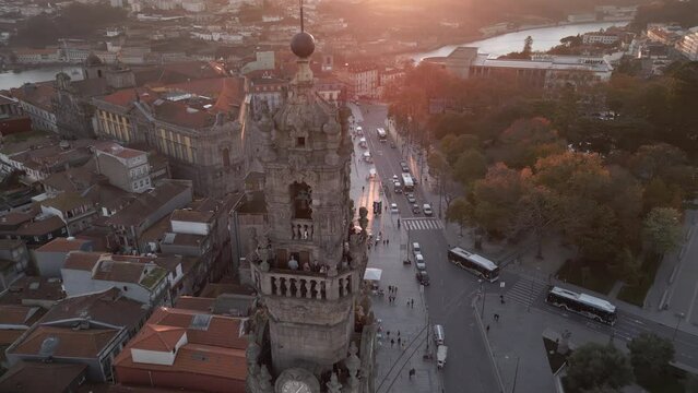 Aerial orbiting shot of historic landmark Clerigos Tower (Portuguese: Torre dos Clerigos) at sunset in Porto (Oporto), Portugal.