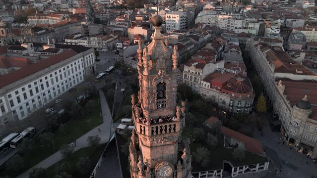 Aerial orbiting shot of historic landmark Clerigos Tower (Portuguese: Torre dos Clerigos) at sunset in Porto (Oporto), Portugal.