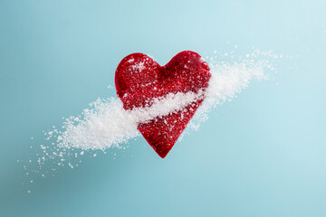Red blood splatter in form of a heart mixed with sugar crystals on blue background, soft focus...
