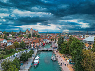 Fototapeta na wymiar Annecy city center panoramic aerial view over the old town, castle, Thiou river and mountains surrounding the lake. Annecy is known as the Venice of the French Alps