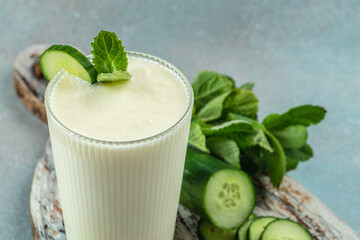 Homemade yogurt drink Ayran with fresh cucumber on a blue background, clean eating for weight loss. place for text